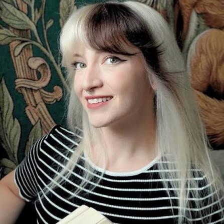 Smiling person with striped shirt and distinctive two-tone hair